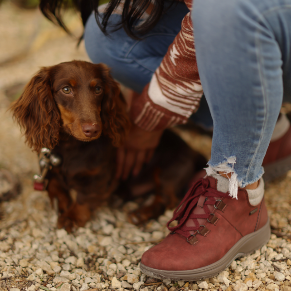 Woman holding dog crouching down 