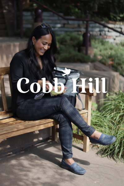 Woman eating a salad on park bench with Cobb Hill shoes on