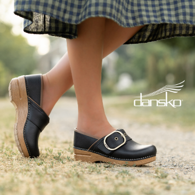 Woman standing on sidewalk wearing Dansko clogs