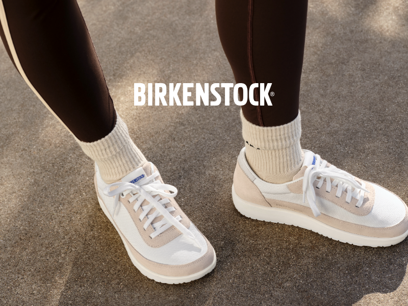 Woman sitting on ledge wearing Birkenstock sneakers