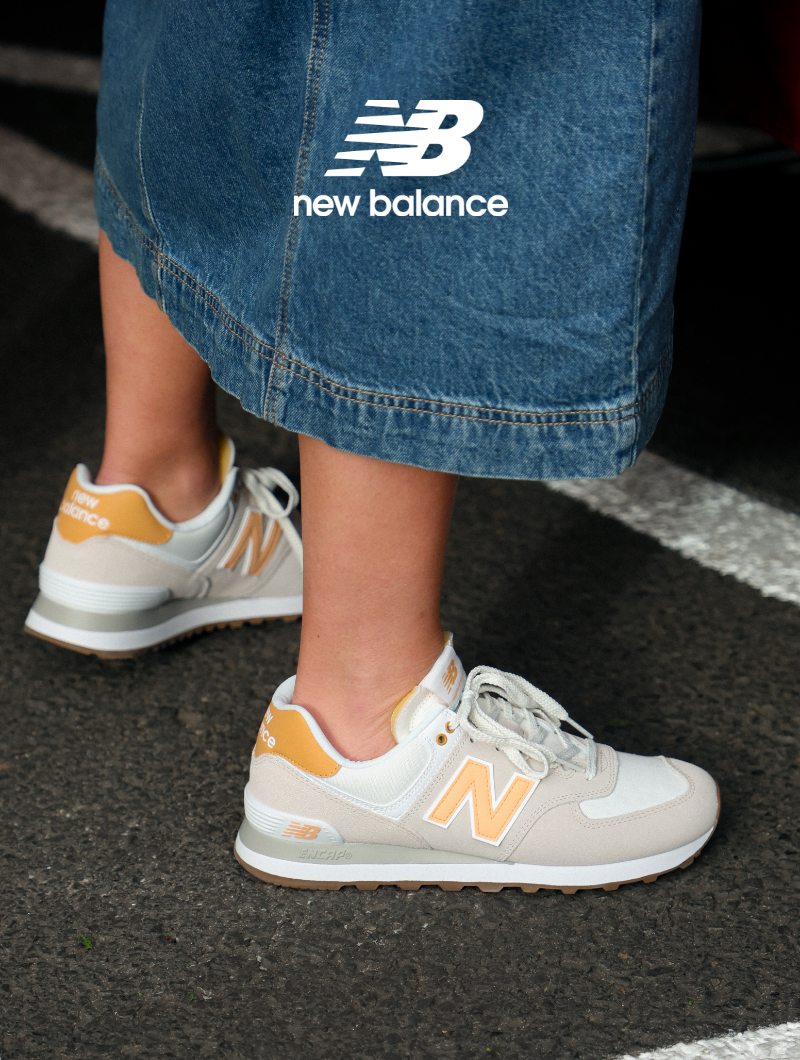 Woman standing at farmer's market wearing New Balance lifestyle sneakers