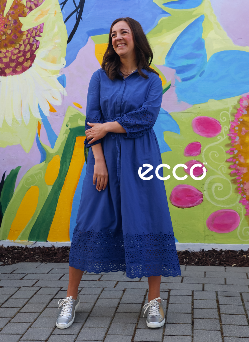 Woman standing in front of mural wearing Ecco sneakers