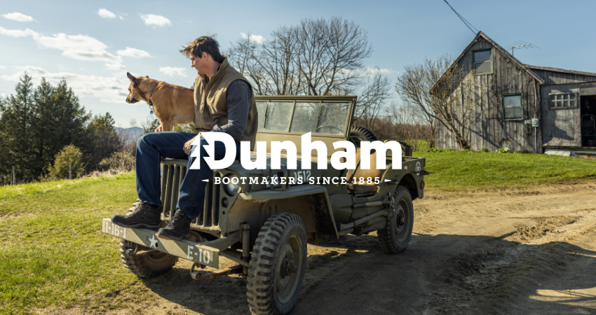 Man sitting on Jeep with dog