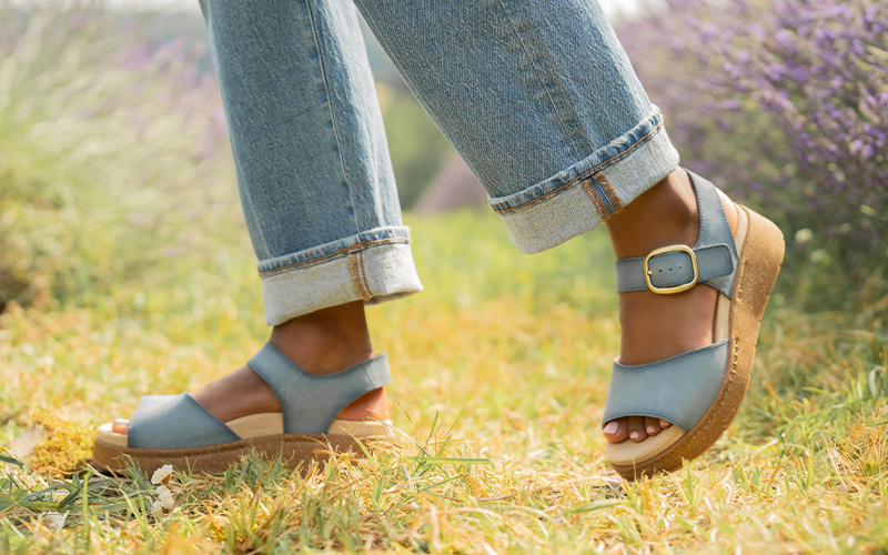 Woman wearing Dansko Bonita sandals standing in a field of lavender