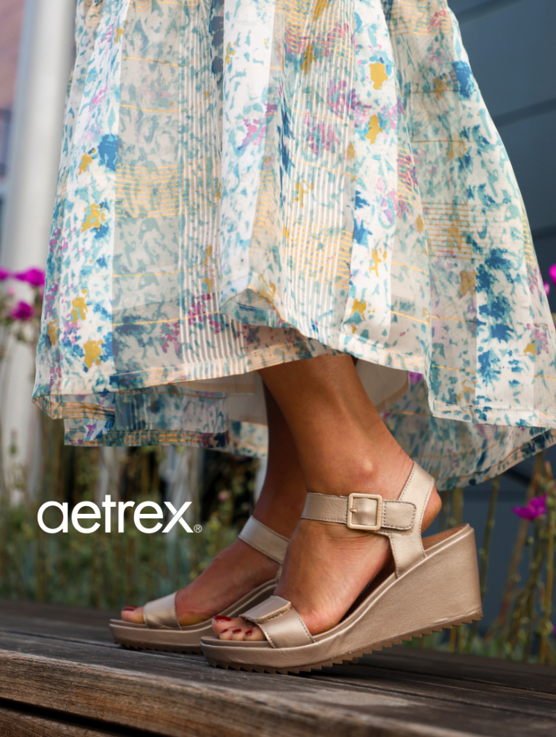 Woman standing on bench wearing Aetrex heeled sandals