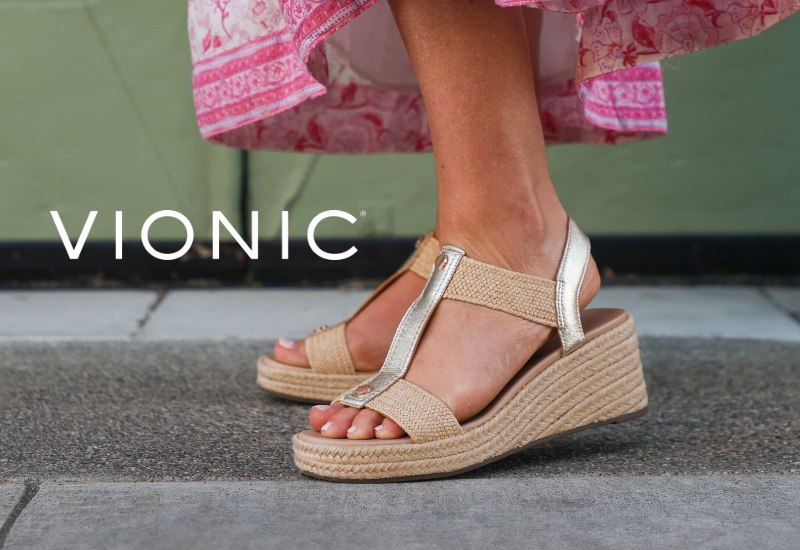 Woman standing on sidewalk wearing Vionic sandals