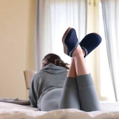 Woman crossing legs reading a book