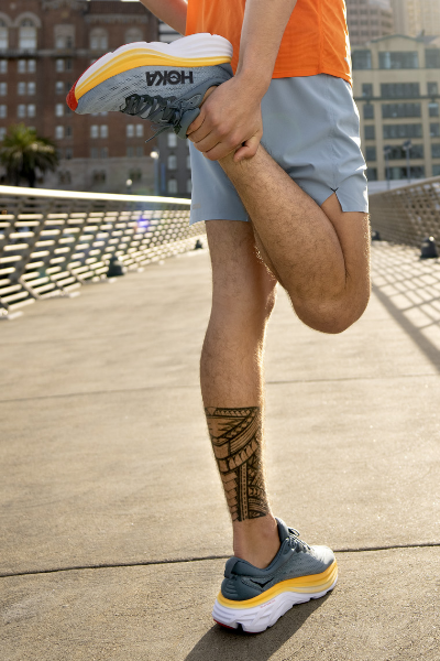 Man stretching in Hoka shoes