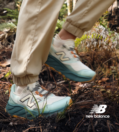 Woman walking through woods in New Balance hike