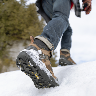 Man walking up snow pile