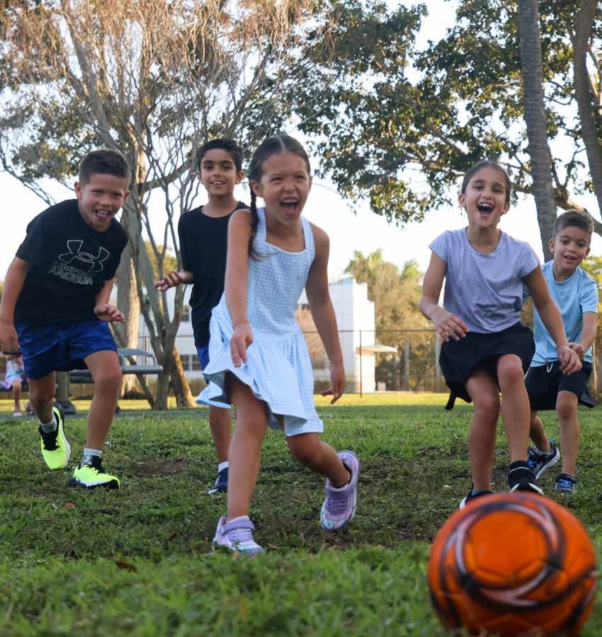 Kids running towards soccer ball