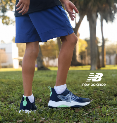 Kid running in grass in New Balance sneakers
