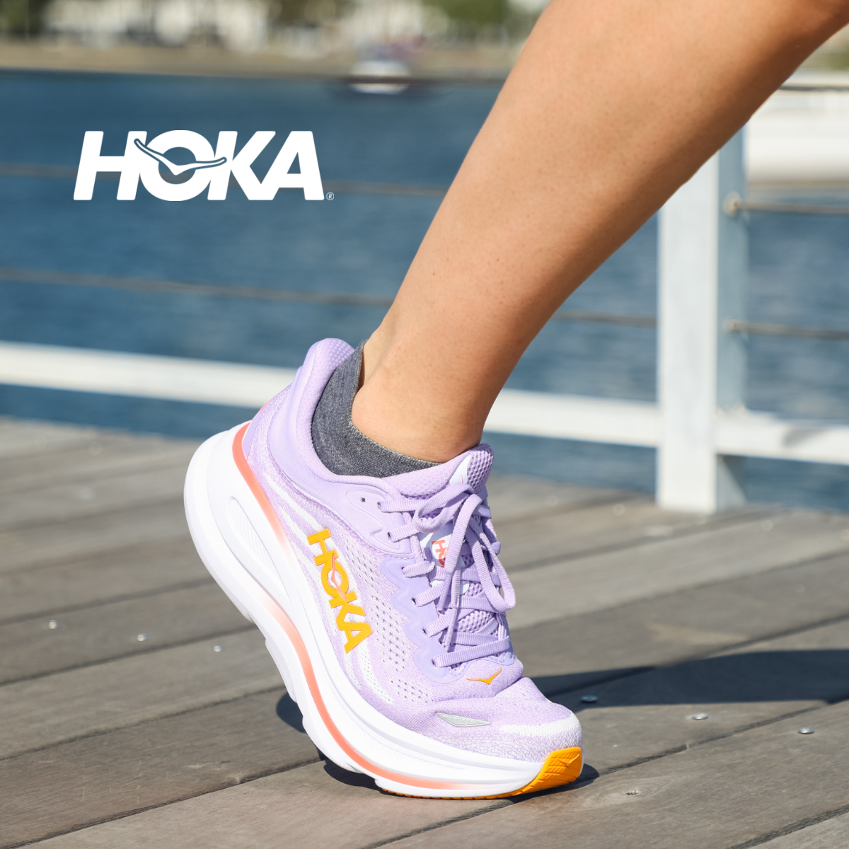 Woman walking on sidewalk wearing Hoka Bondi 9's