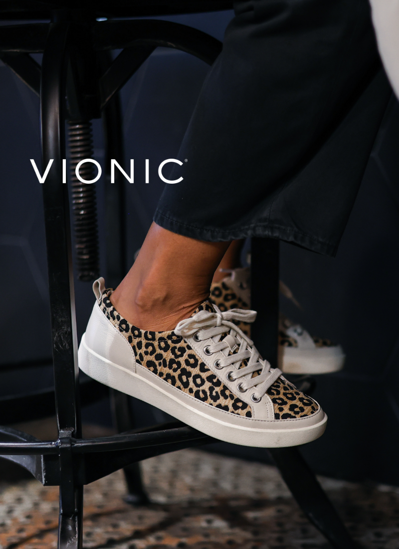 Woman sitting on barstool wearing Vionic sneakers