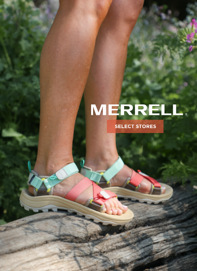 Woman standing on log wearing Merrell sandals
