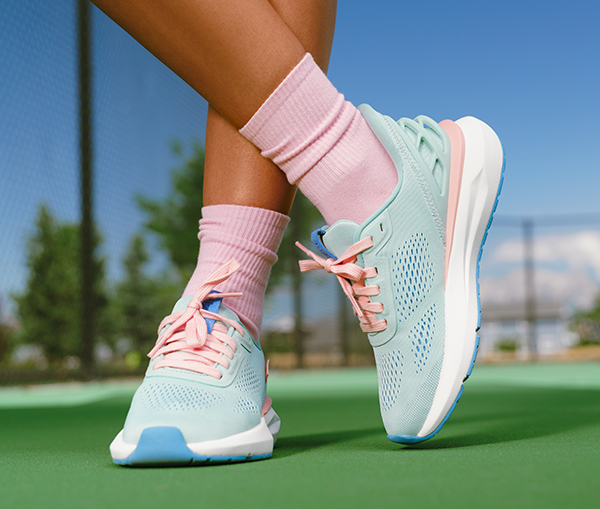 Kizik Athens 2 Woman wearing Kizik Athens 2 blue and pink sneakers on a tennis court