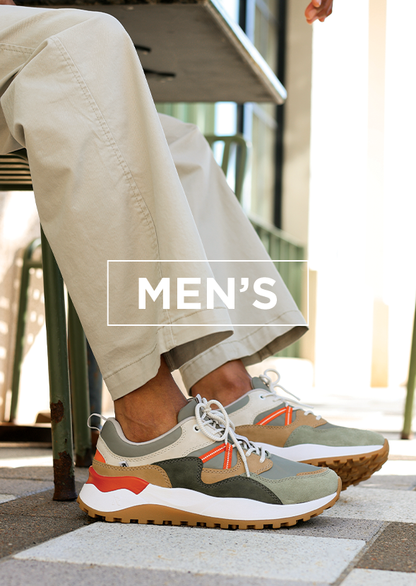 Man wearing sneakers sitting at a table
