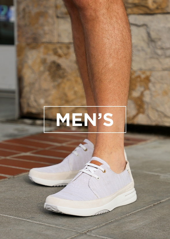 Close up of man wearing sneakers standing on the sidewalk with overlay text "MENS"