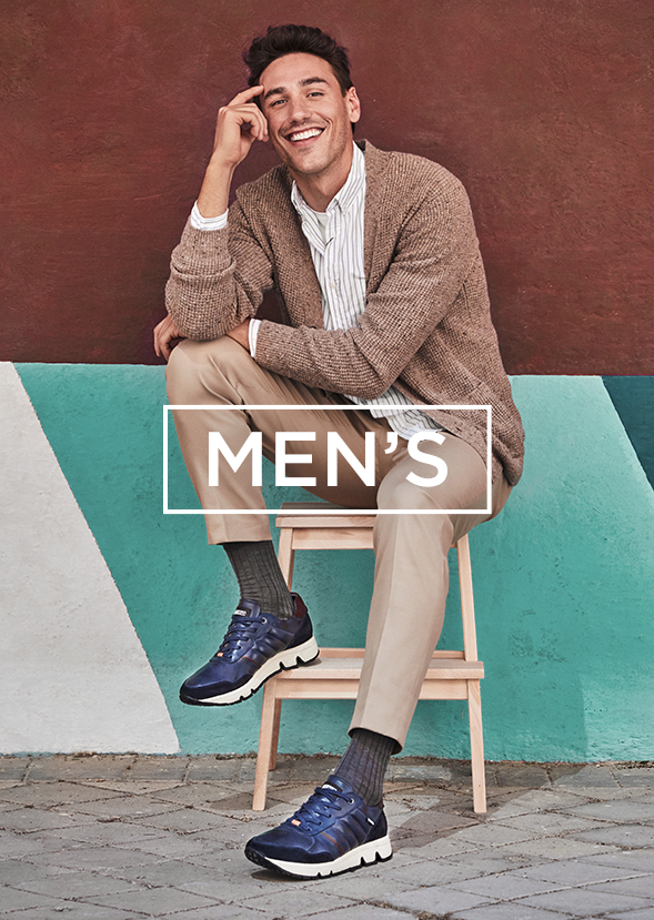 Man sitting on stool wearing blue tennis shoes
