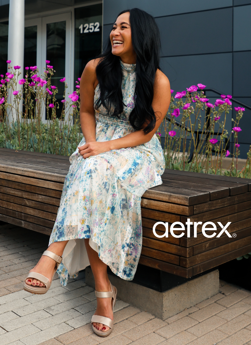Woman sitting on bench wearing Aetrex sandals