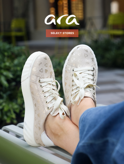 Woman crossing feet on bench wearing Ara sneakers