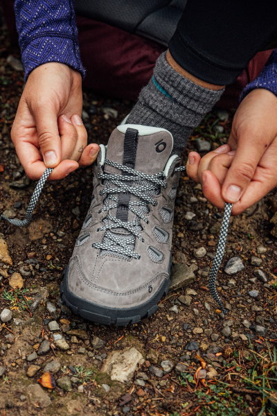 Woman tying shoe on ground