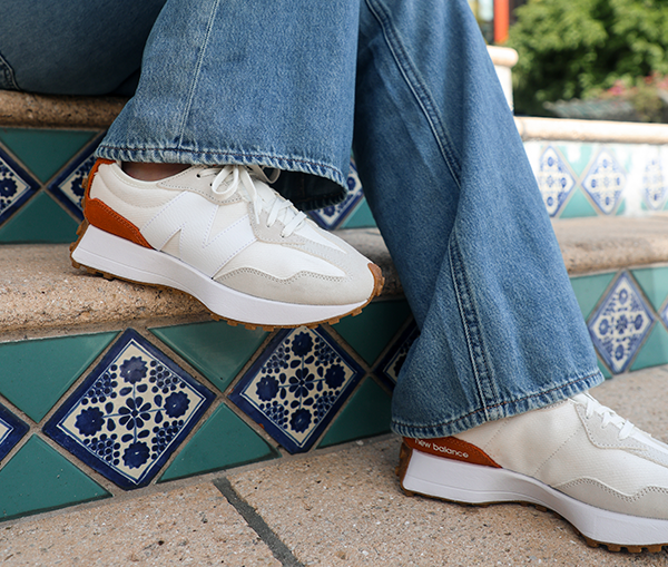 New Balance 327 Woman wearing a denim jumpsuit wearing New Balance 372 retro sneakers