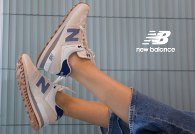 Woman kicking New Balance 574 Lifestyle shoes in air