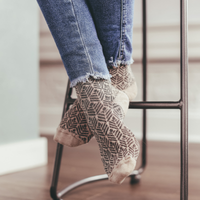 Woman sitting on barstool with feet crossed