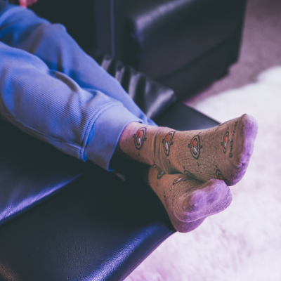 Man sitting on couch with legs crossed