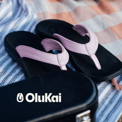 Olukai sandals sitting on towel