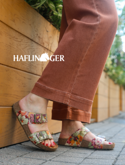 Woman leaning heels against wall in Haflinger