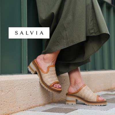 Woman leaning feet against curb in Salvia sandals