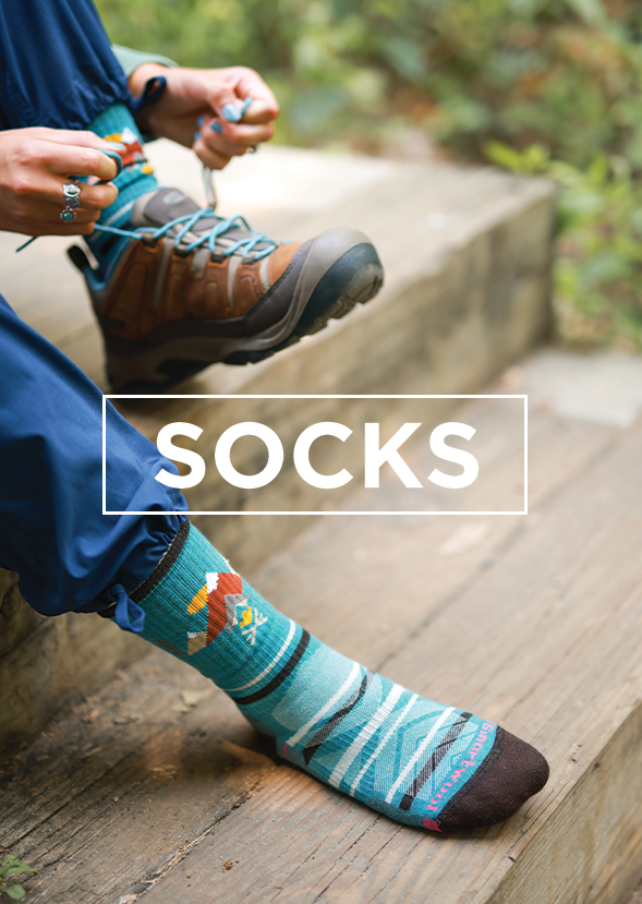 human sitting on steps wearing socks while putting on shoes