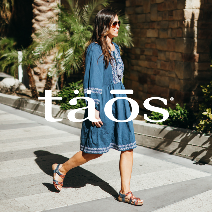 Woman walking on sidewalk in shopping center