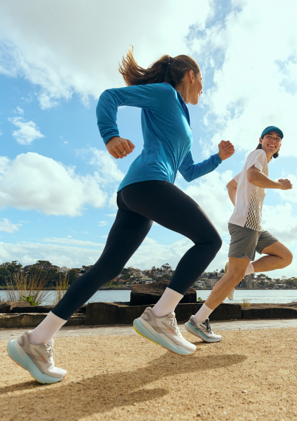 People running next to the ocean in Brooks shoes