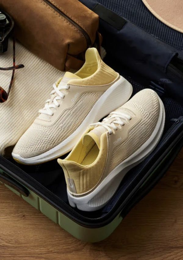 Pair of OluKai sneakers in an open suitcase
