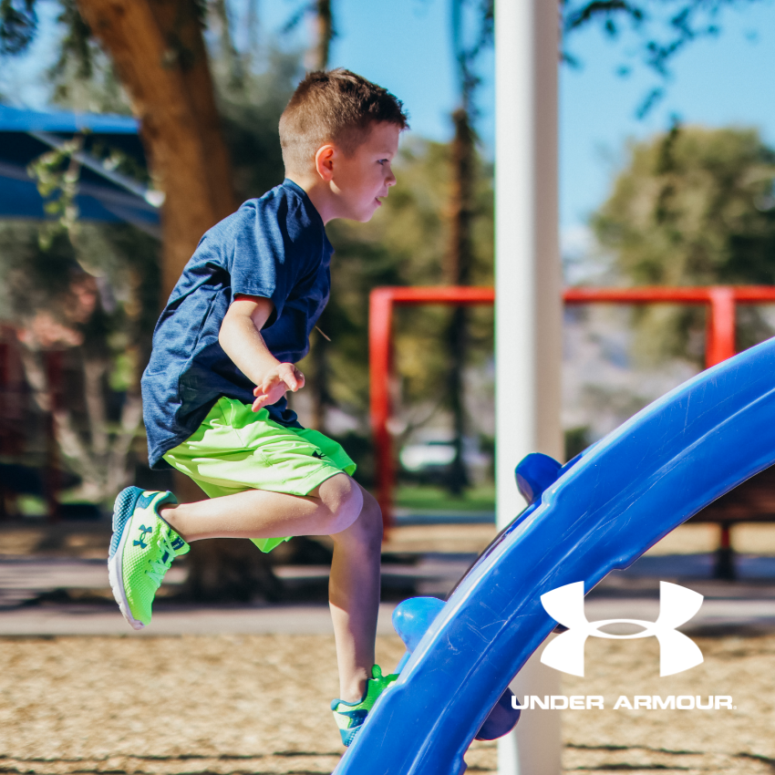 Boy running up slide on playground